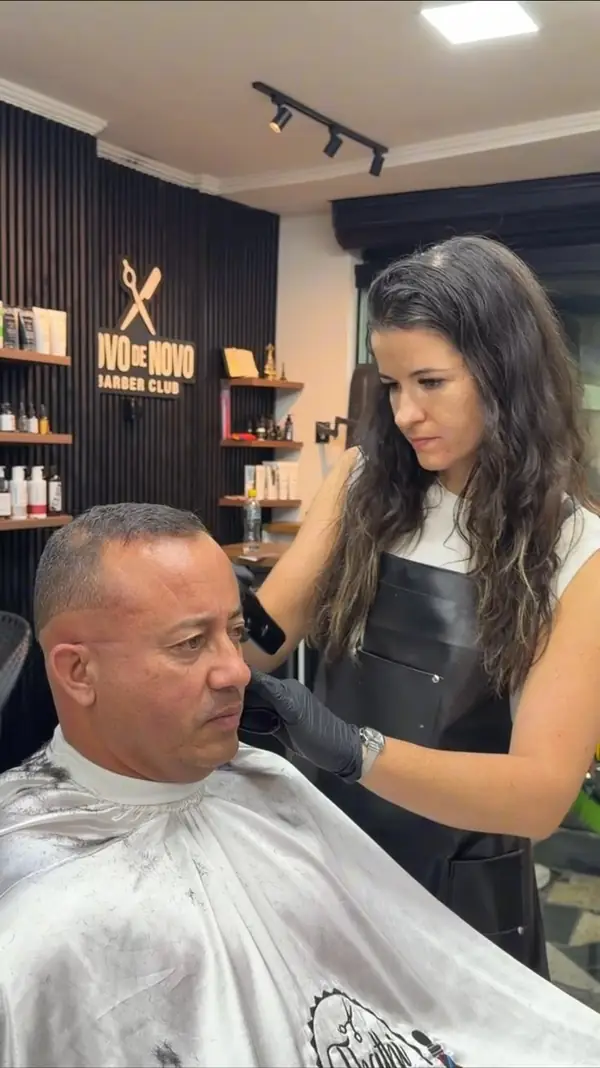 Thathiane Dias fazendo o degradê de disfarce em um cliente na barbearia